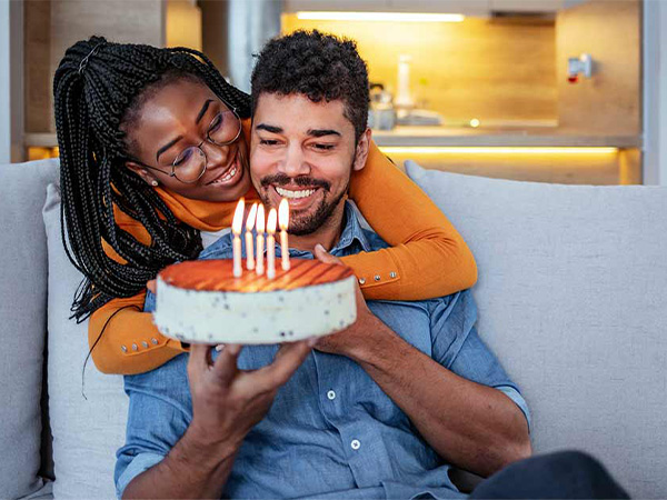 a couple celebrating a birthday with a cake and candles