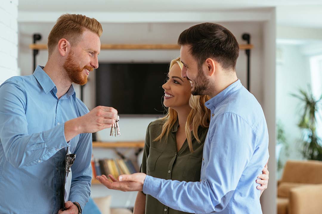 landlord handing couple keys