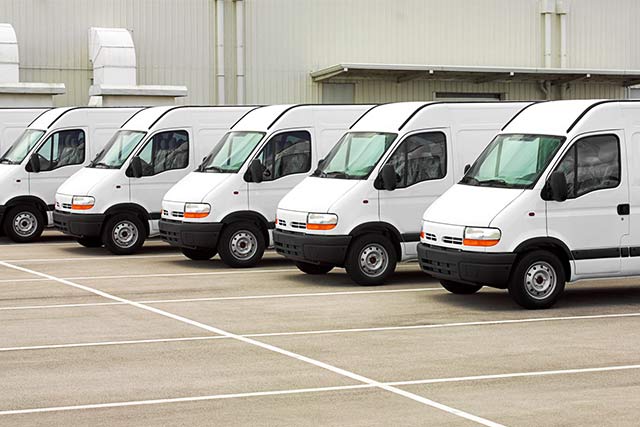 A fleet of white commercial vans